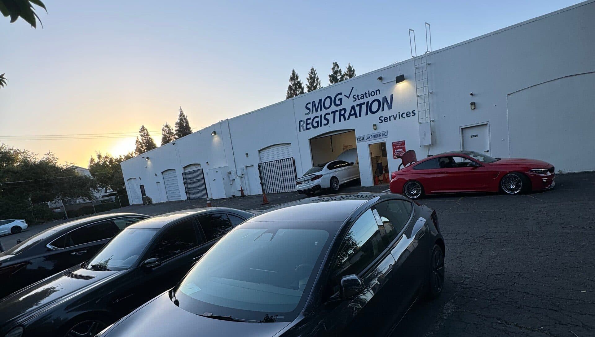 Dave's Smog & Registration building at sunset, with cars in the lot and the SMOG Station Registration Services lettering